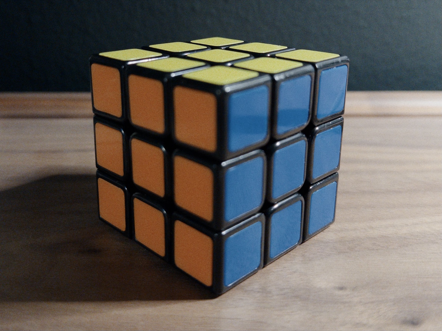 A solved Rubik's Cube on a wooden table